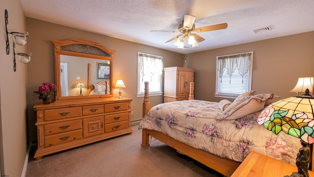 bedroom with light carpet, visible vents, a textured ceiling, and a baseboard radiator