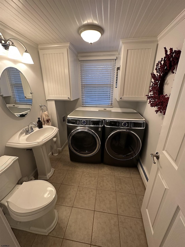 laundry room featuring ornamental molding, a baseboard heating unit, separate washer and dryer, light tile patterned flooring, and laundry area