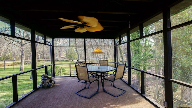 unfurnished sunroom featuring a ceiling fan