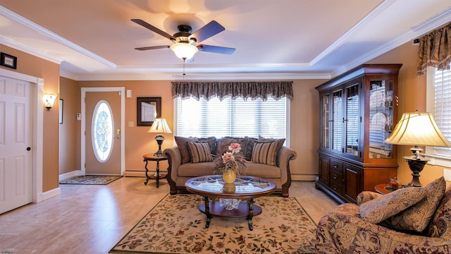 living area with baseboard heating, a raised ceiling, crown molding, and baseboards