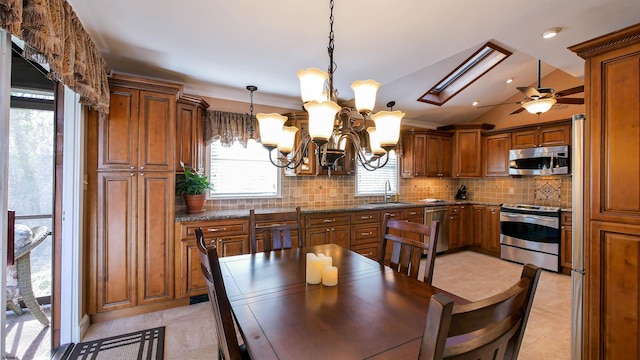 kitchen featuring brown cabinetry, stainless steel appliances, and a sink