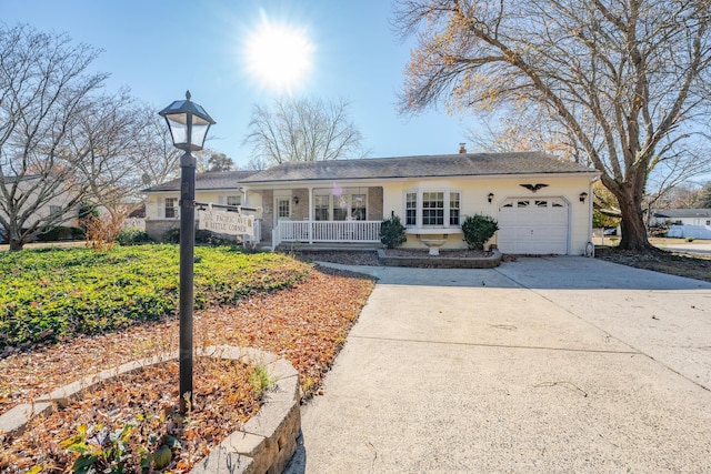 single story home featuring covered porch, an attached garage, and driveway