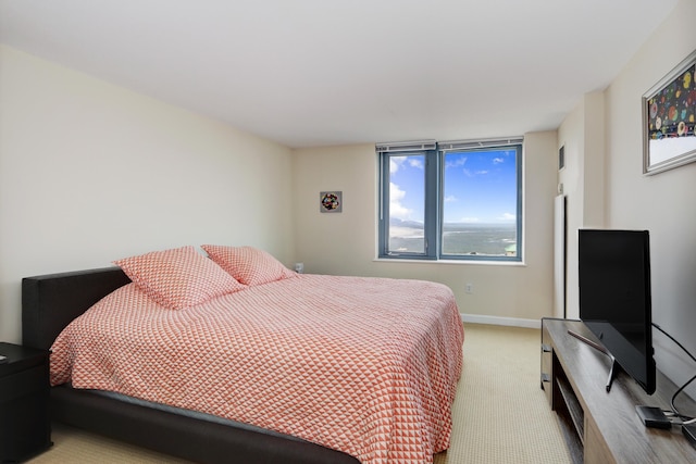 bedroom with baseboards and light colored carpet