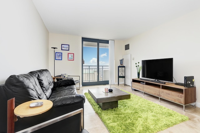 living area with floor to ceiling windows, baseboards, and visible vents