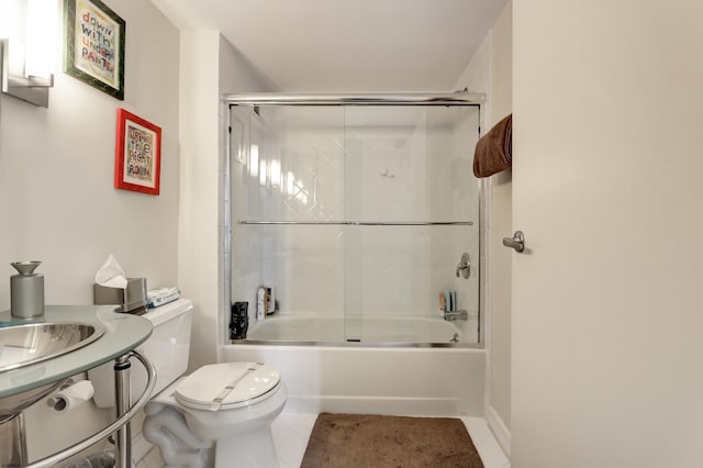 bathroom featuring tile patterned floors, toilet, and bath / shower combo with glass door