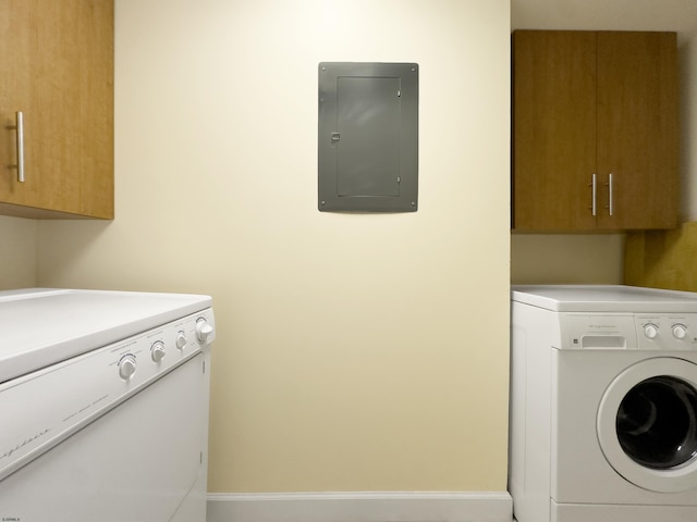 laundry room featuring electric panel, cabinet space, independent washer and dryer, and baseboards