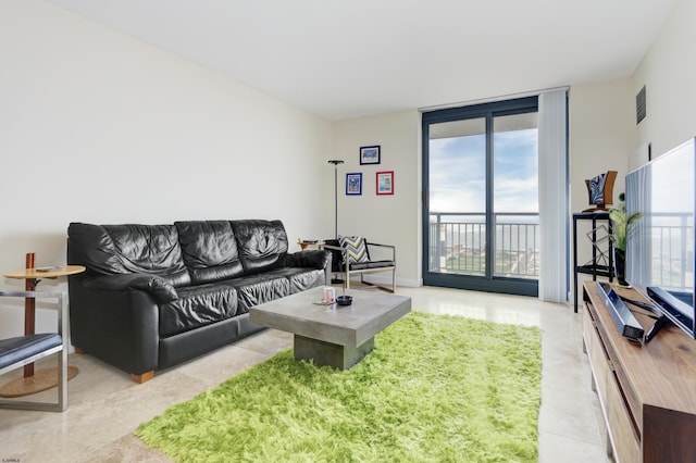 living area featuring light tile patterned flooring, visible vents, and floor to ceiling windows