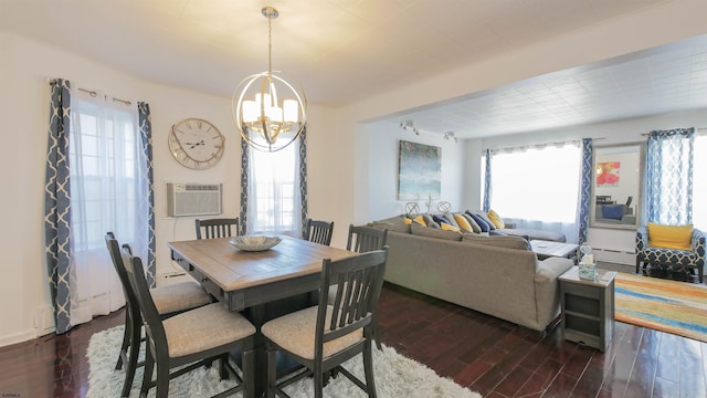 dining space with an inviting chandelier, dark wood-type flooring, and a wall unit AC