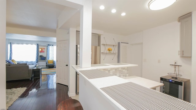 kitchen featuring recessed lighting, wine cooler, wood finished floors, and light countertops