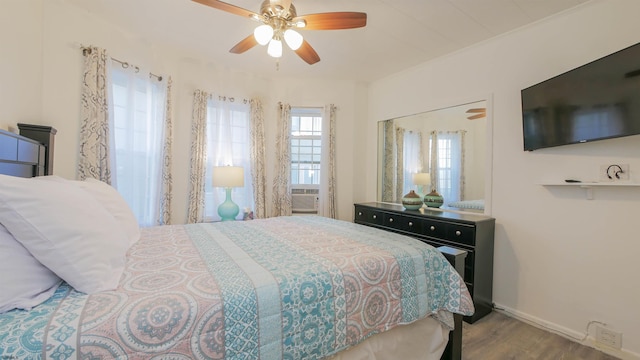 bedroom featuring ceiling fan, baseboards, and wood finished floors