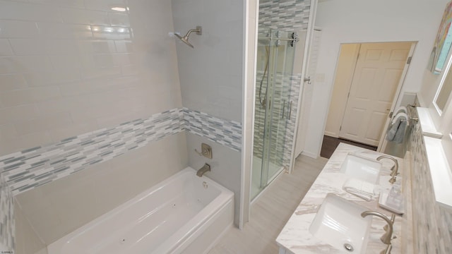 bathroom with a sink, a stall shower, a tub to relax in, and double vanity