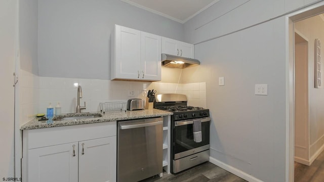 kitchen with under cabinet range hood, a sink, backsplash, white cabinetry, and appliances with stainless steel finishes