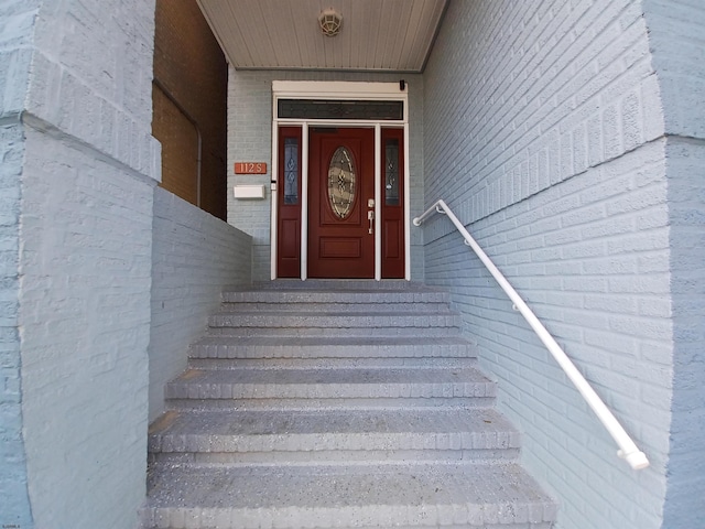 view of exterior entry featuring brick siding