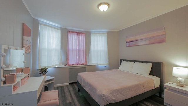 bedroom with wood finished floors, radiator, and ornamental molding