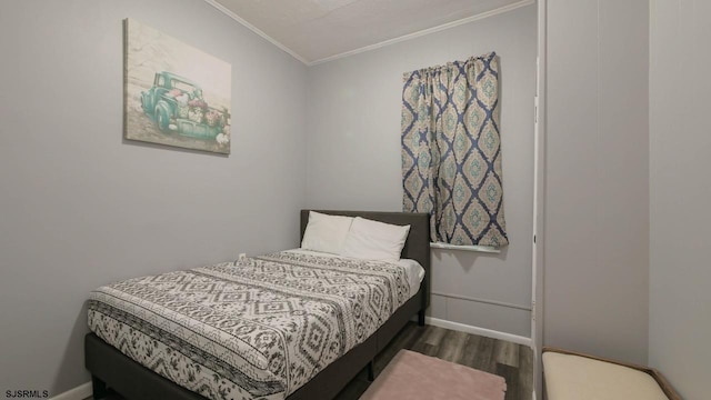 bedroom featuring wood finished floors, baseboards, and ornamental molding