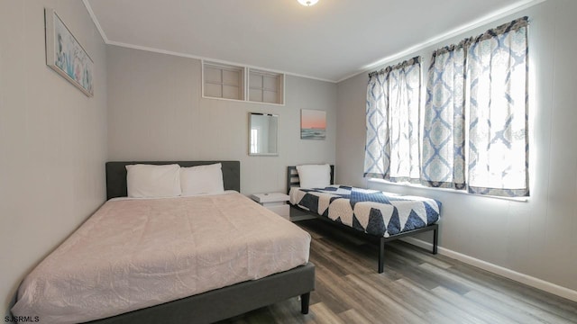 bedroom with baseboards, wood finished floors, and crown molding