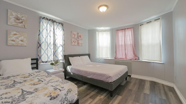 bedroom with baseboards, radiator heating unit, dark wood-type flooring, and ornamental molding