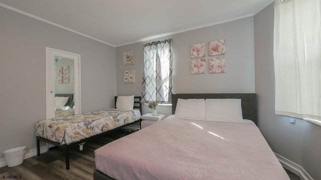 bedroom featuring crown molding, wood finished floors, and baseboards