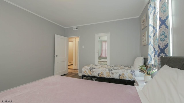 bedroom featuring visible vents, wood finished floors, ornamental molding, and a baseboard radiator