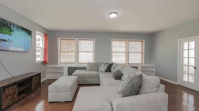 living area featuring baseboards and dark wood-type flooring