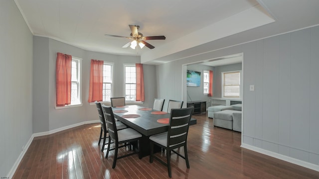 dining area with dark wood-style floors, a ceiling fan, and baseboards