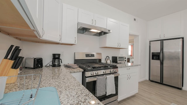 kitchen featuring white cabinetry, light stone countertops, under cabinet range hood, and stainless steel appliances