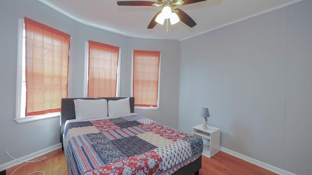 bedroom with ceiling fan, baseboards, and wood finished floors