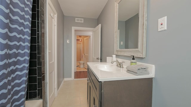 bathroom featuring tile patterned floors, visible vents, toilet, curtained shower, and vanity