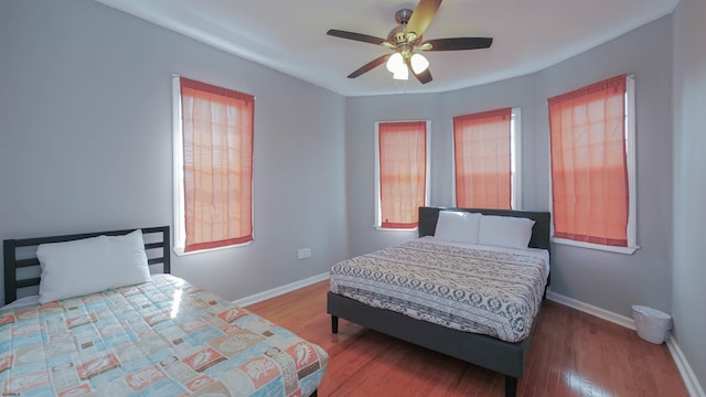 bedroom with ceiling fan, baseboards, and wood finished floors