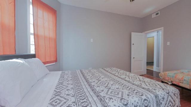 bedroom with dark wood finished floors and visible vents