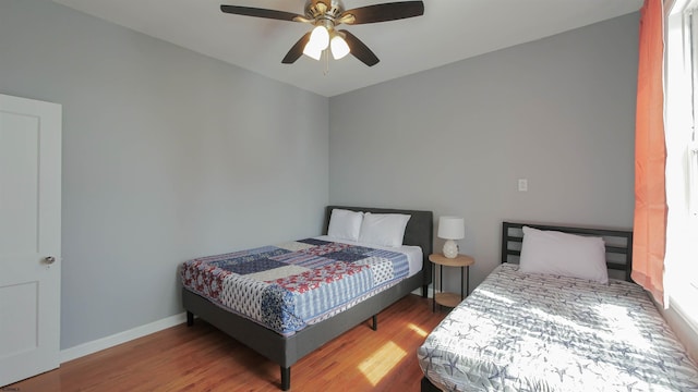 bedroom with wood finished floors, baseboards, and ceiling fan