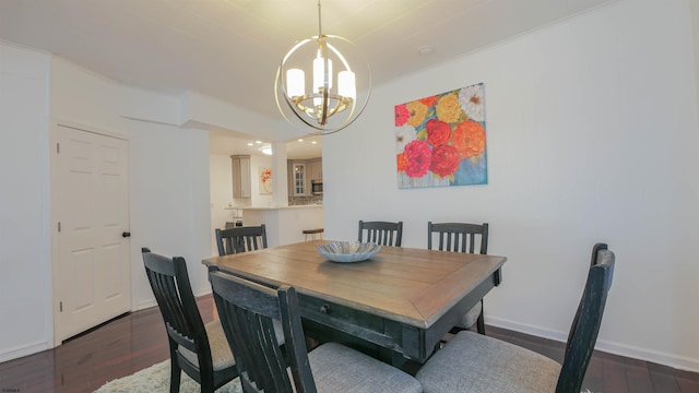 dining space with baseboards, a notable chandelier, and wood finished floors