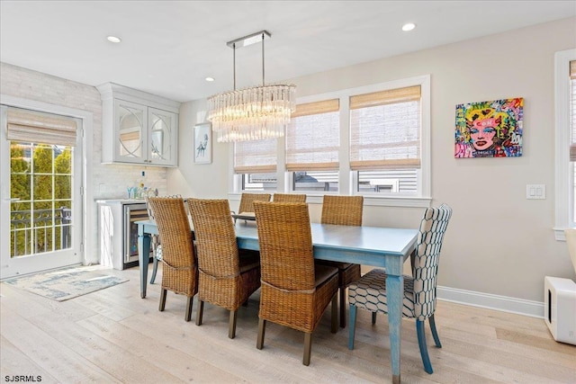 dining area featuring baseboards, an inviting chandelier, recessed lighting, wine cooler, and light wood-type flooring