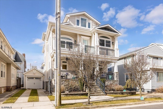 townhome / multi-family property with a detached garage, stairway, covered porch, a balcony, and driveway