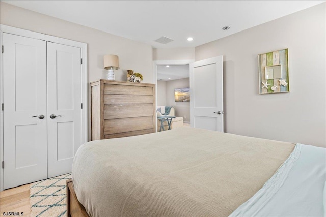 bedroom with visible vents, recessed lighting, wood finished floors, and a closet