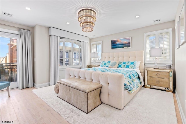 bedroom with access to exterior, wood finished floors, visible vents, and a chandelier