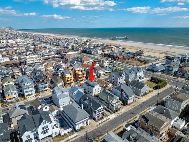 birds eye view of property with a water view and a beach view