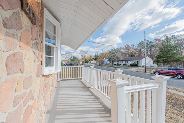 balcony featuring covered porch and a residential view