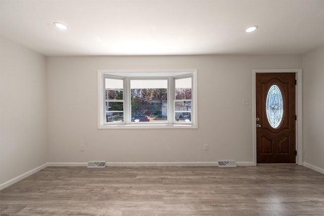 foyer with visible vents, baseboards, and light wood-style flooring