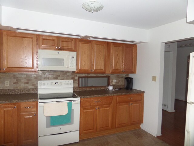 78 Tyler Rd, Greenfield, NJ 08230 - kitchen with dark countertops, backsplash, white appliances, and brown cabinets