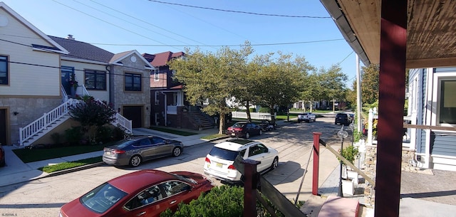 view of street featuring sidewalks, stairway, curbs, and a residential view