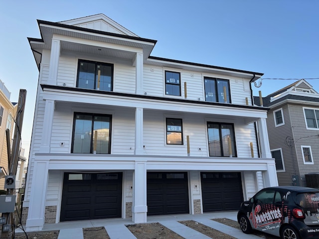 view of front of home featuring stone siding, a balcony, board and batten siding, and a garage