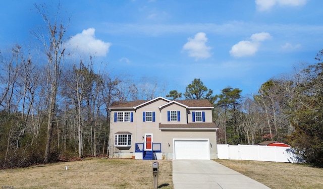 view of front of home featuring a front lawn, an attached garage, fence, and driveway