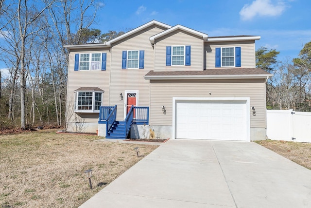 view of front facade with an attached garage, concrete driveway, a front lawn, and fence