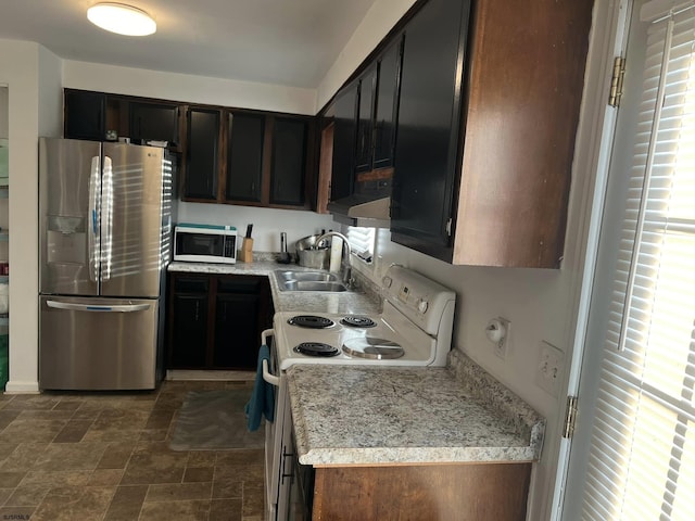 kitchen with stone finish floor, a sink, stainless steel appliances, light countertops, and extractor fan