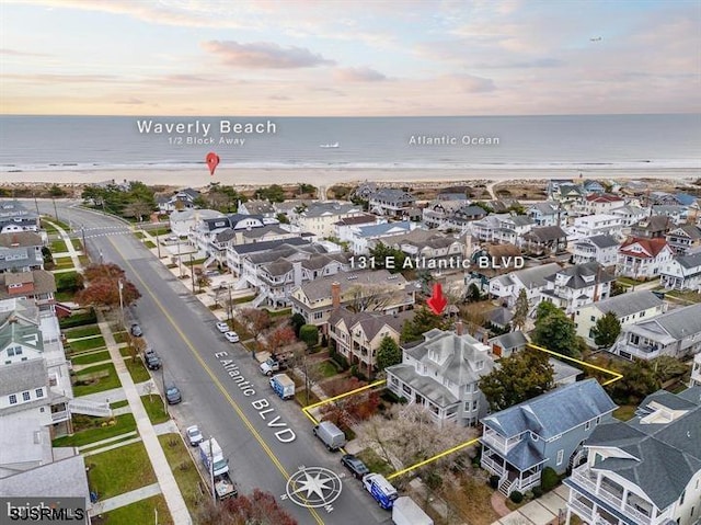 bird's eye view featuring a beach view, a water view, and a residential view