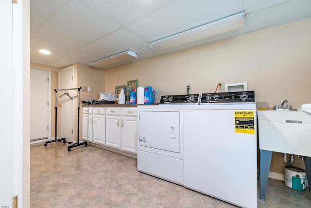 washroom with washer and dryer, cabinet space, and a sink