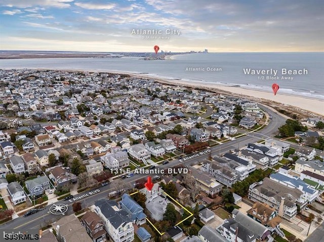 birds eye view of property with a residential view, a water view, and a beach view