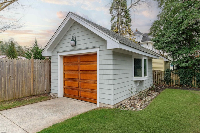 view of outdoor structure with driveway, an outdoor structure, and fence