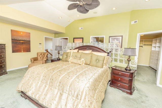 bedroom featuring visible vents, a walk in closet, baseboards, lofted ceiling, and carpet floors